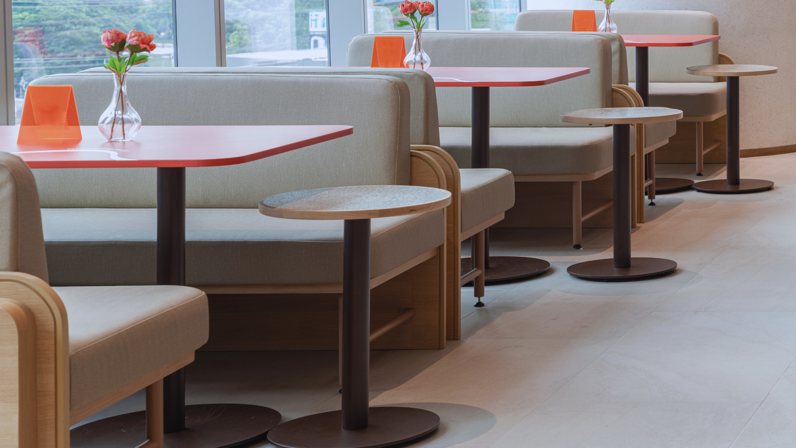 Modern cafeteria tables and sofa type chairs in a lounge.